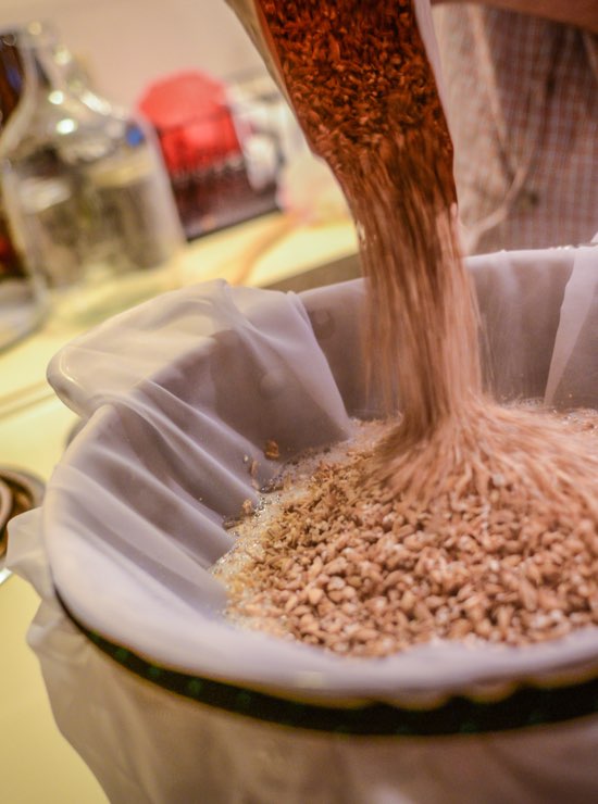 Crushed malt pouring into a brew in a bag