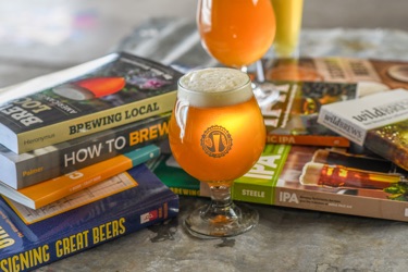 stack of beer books with glasses of beer
