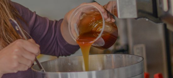 Homebrewer adds malt extract to brew kettle